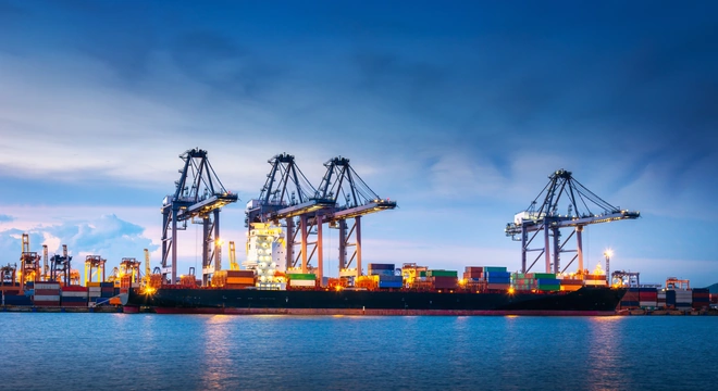 Container port with ship-to-shore cranes at dusk