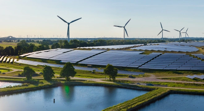 Solar PV power plant with wind turbines beside water ponds