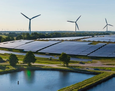 Solar PV power plant with wind turbines beside water ponds