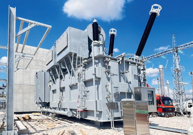 Side view of the 400 kV transformer with control cabinet and substation gantries in Greece