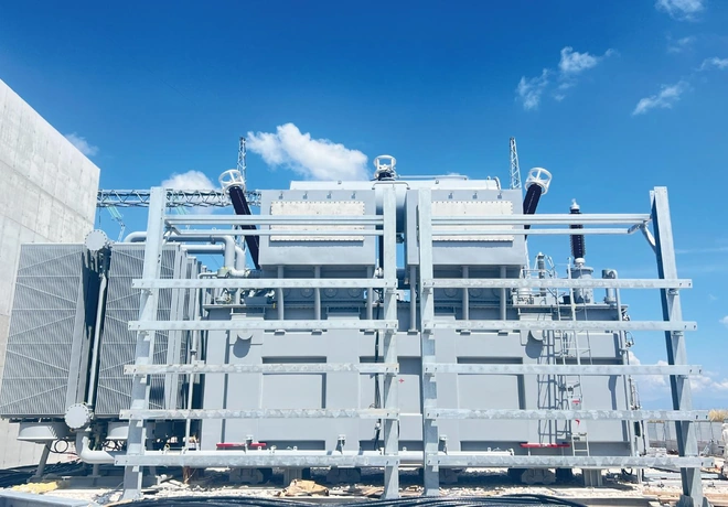 Front view of the split-winding power transformer behind a galvanized steel support frame