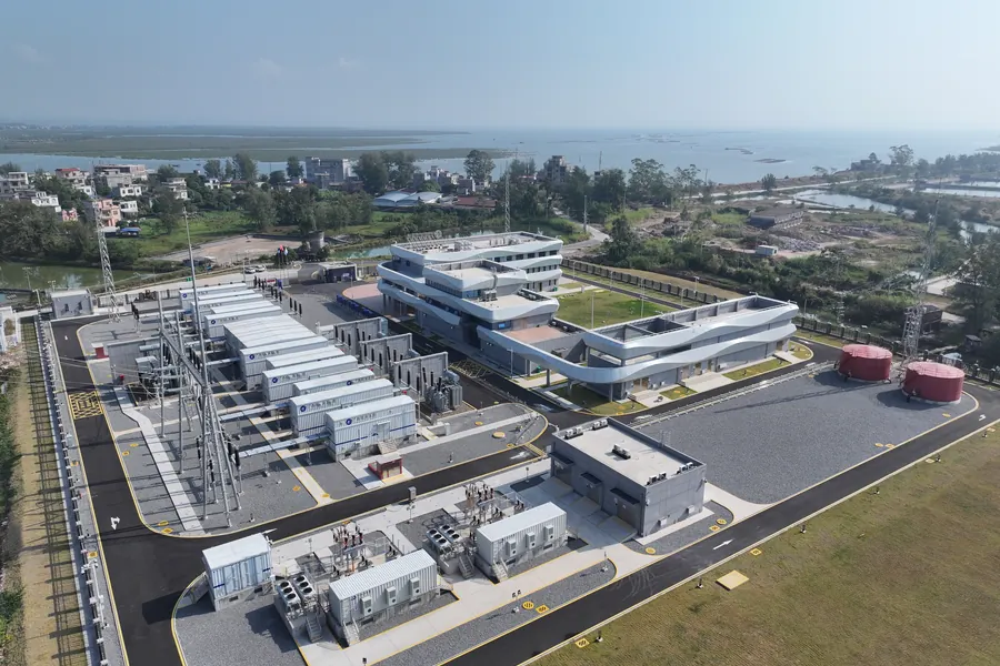 Aerial view of a coastal industrial facility with modular E-Houses beside an outdoor substation