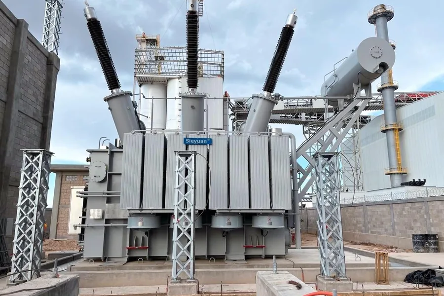 Outdoor power transformer with bushings and lightning arresters at an industrial plant substation