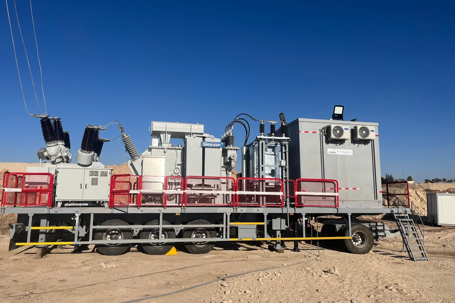 Trailer-mounted mobile substation transformer parked at a desert site